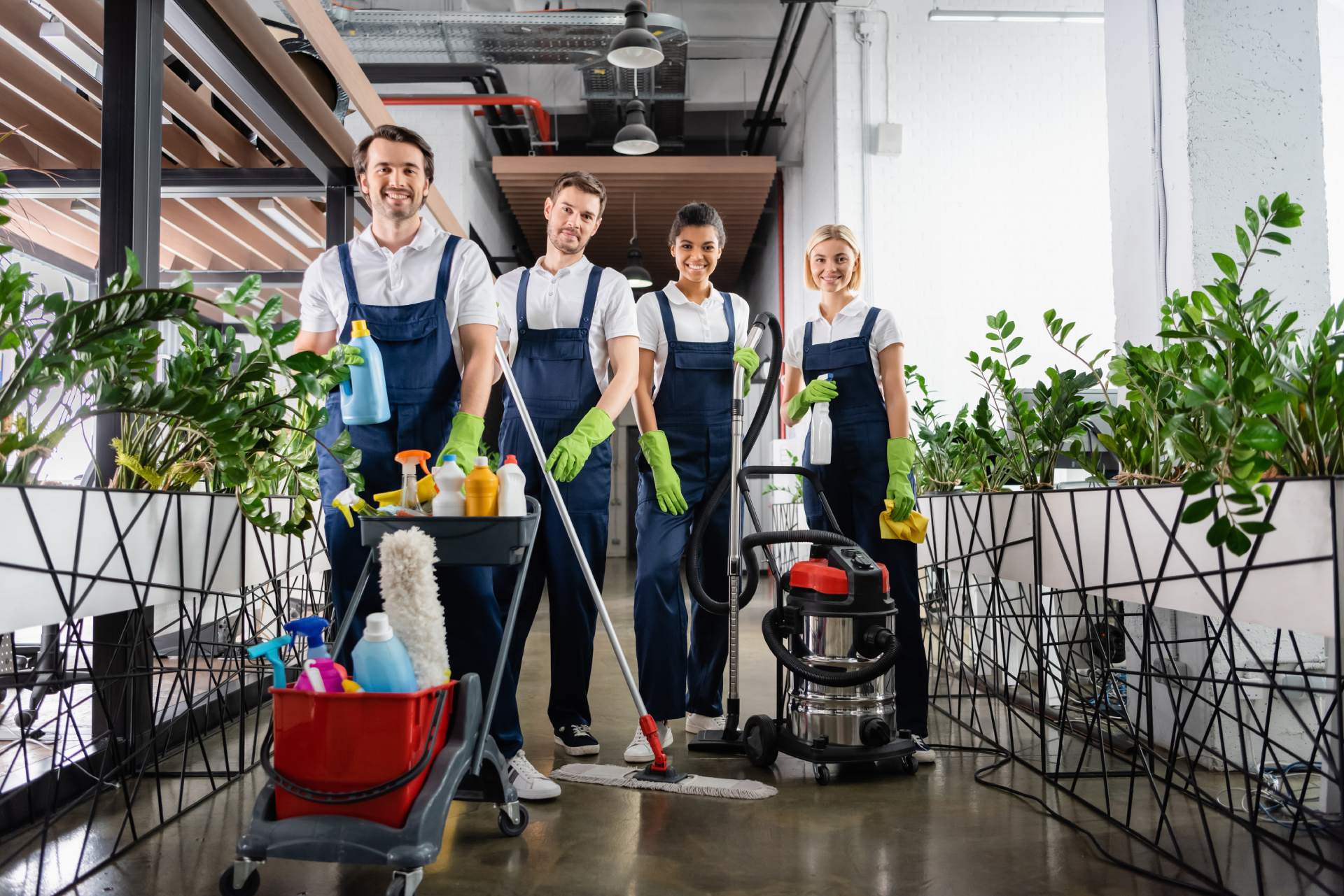 Group of professional cleaners posing for a photo while holding cleaning materials